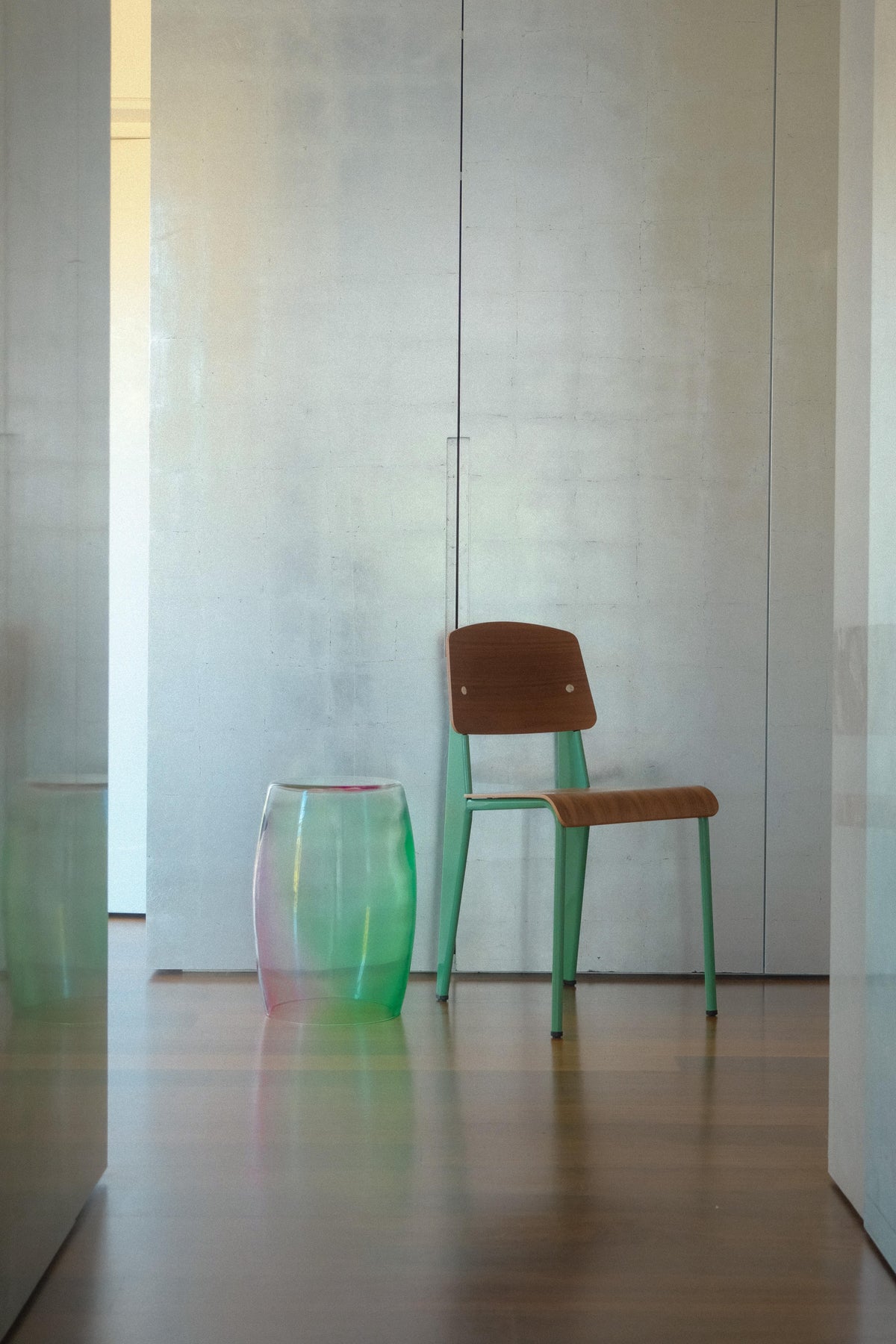 Tavolino Menta Viola 50 Murano glass table in amethyst and green beside a wooden chair in a modern minimal interior.