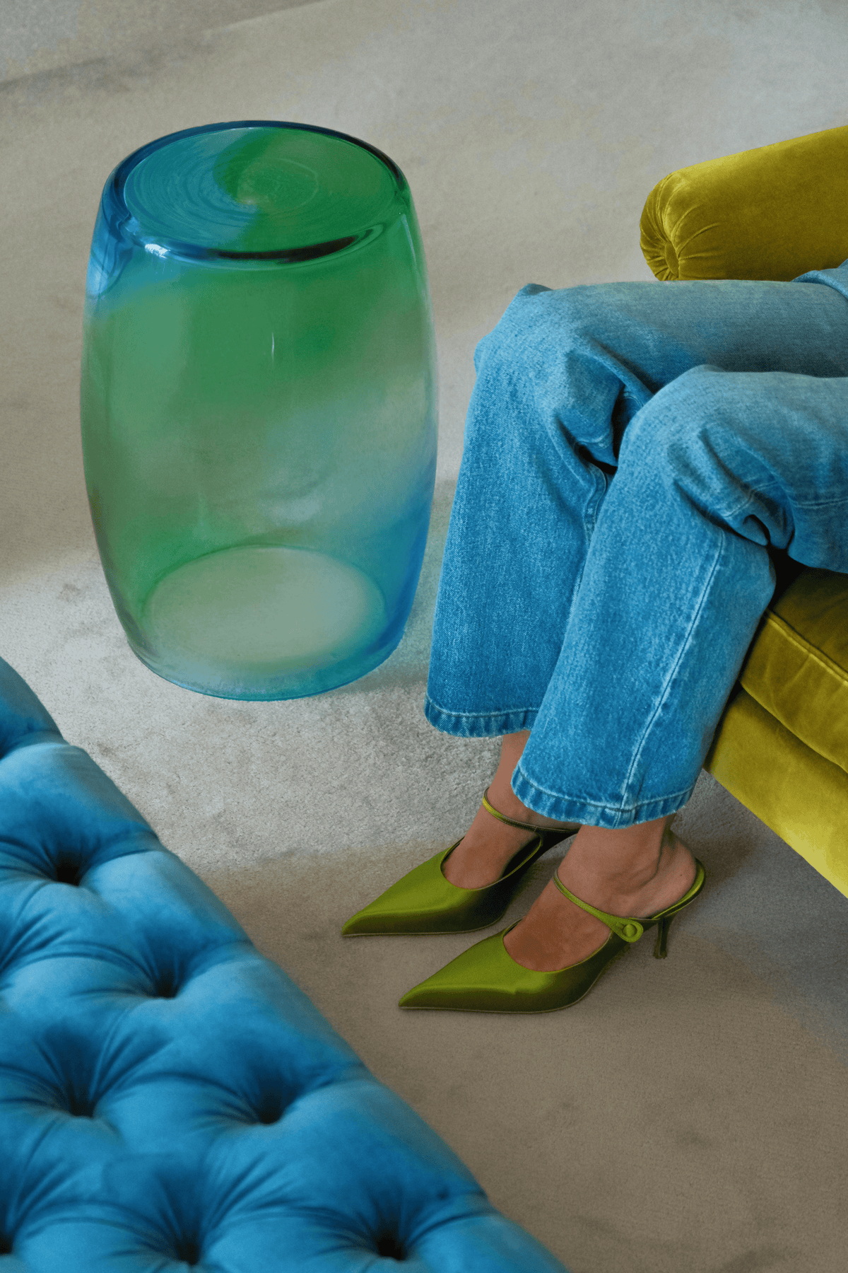 Tavolino Laguna 50 in aquamarine and green beside a velvet sofa, Murano glass table.